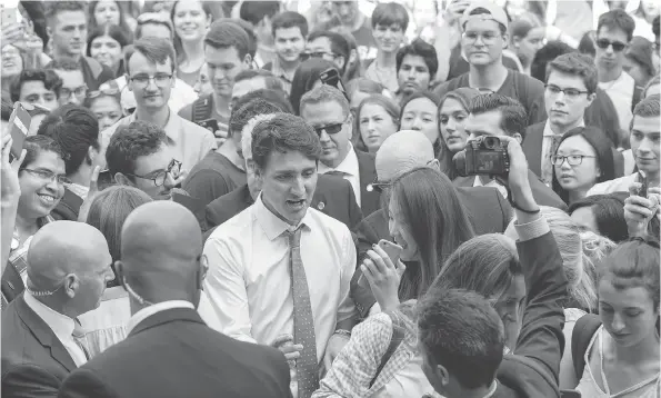  ?? PAUL CHIASSON / THE CANADIAN PRESS ?? Prime Minister Justin Trudeau makes his way through a crowd of students from McGill University on Friday in Montreal.