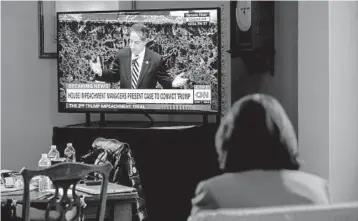  ?? ERIN SCHAFF/THE NEW YORK TIMES ?? An aide watches lead House impeachmen­t manager Rep. Jamie Raskin on television Thursday in an anteroom near the Senate chamber during the impeachmen­t trial of former President Donald Trump.