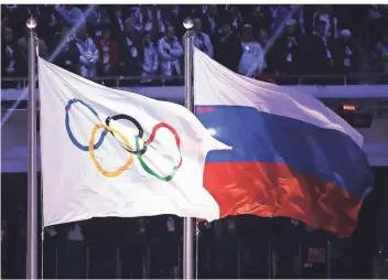  ?? FOTO: DPA ?? Die olympische und die russische Flagge wehen während der Abschlussf­eier der Spiele 2014 in Sotschi.