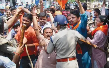  ?? — PTI ?? Policemen scuffle with Akhil Bharatiya Vidyarthi Parishad workers in Allahabad on Thursday during a protest against the leaking of the question paper of the Uttar Pradesh Public Service Commission ( preliminar­y) exam.