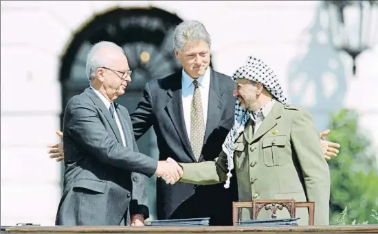  ?? J. DAVID AKE / AFP ?? Yitzhak Rabin estrecha la mano de Yasir Arafat bajo la mirada complacien­te de Bill Clinton en Washington el 13 de septiembre de 1993