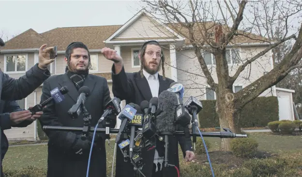  ?? PICTURE: KENA BETANCUR/AFP/GETTY ?? 0 Joseph Gluck, right, talks to the press as he describes the attack in the home of Rabbi Chaim Rottenberg in the suburb of Monsey