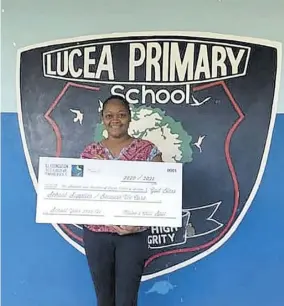  ?? (Photos: JIS) ?? Principal of Lucea Primary School Yazmin Anderson Jackson displays the token cheque for stationery and other school supplies donated to the school by the I Love Lucea Foundation, recently.