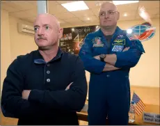  ?? AP Photo/dMItry LoVetSky ?? In this 2015 file photo, U.S. astronaut Scott Kelly (right) crew member of the mission to the Internatio­nal Space Station, stands behind glass in a quarantine room, behind his brother, Mark Kelly, also an astronaut, after a news conference in the Russian-leased Baikonur, Kazakhstan cosmodrome.