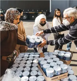  ??  ?? TAKING CARE. A volunteer from Muslims for Humanity hands out baby food at the NMJ Islamic Centre in Durban on Saturday.