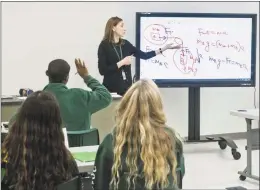  ?? Scott Mullin / For Hearst Connecticu­t Media ?? Trinity Catholic teacher Penka Petkova working with students in the newly renovated physics room at the high school. Trinity Catholic announced this week a nine-person board of directors will now make decisions on tuition rates, budgeting and other matters.