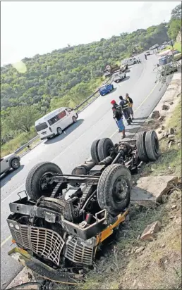  ?? PHOTOGRAPH: NIGEL LOUW ?? FAMILIAR SIGHT: An accident scene in the Kei Cuttings where a truck transporti­ng a bulldozer lost control and smashed into a bakkie