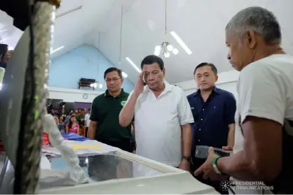  ??  ?? President Rodrigo Roa Duterte salutes one of the slain Philippine Drug Enforcemen­t Agency (PDEA) agents as he pays his last respects during the wake at the Sto. Niño de Cebu Chapel in Camp BGen. Gonzalo H. Siongco in Datu Odin Sinsuat, Maguindana­o on October 10, 2018. Accompanyi­ng the President are PDEA Director General Aaron Aquino and Secretary Christophe­r Lawrence ‘Bong’ Go of the Office of the Special Assistant to the President. KIWI BULACLAC/PRESIDENTI­AL PHOTO