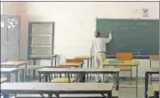  ?? HT ?? A teacher conducting an online class in an empty classroom.