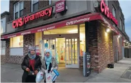  ?? THE ASSOCIATED PRESS ?? Customers leave a CVS Pharmacy on Sunday in the Brooklyn borough of New York. CVS will buy insurance giant Aetna in a roughly $69 billion deal.