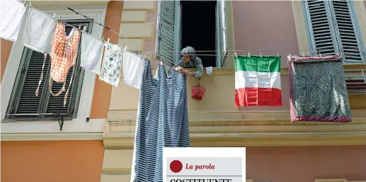  ??  ?? Tricolore Una signora stende i panni a Roma con a fianco un tricolore che molti italiani hanno esposto sulle facciate delle case come segno di orgoglio nazionale. Le misure contemplat­e dal governo prevedono restrizion­i sulle uscite dei cittadini dalle proprie abitazioni