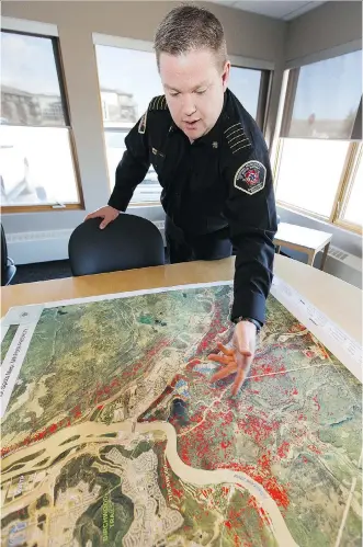  ?? IAN KUCERAK ?? Regional Municipali­ty of Wood Buffalo fire Chief Jody Butz, looking at a map of how the wildfire spread through Fort McMurray and forced people to evacuate on May 3, 2016, reflects prior to the anniversar­y on how the fight against Fire 9 unfolded.