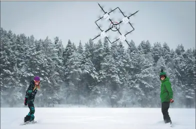  ?? ILMARS ZNOTINS / AGENCE FRANCE-PRESSE ?? Snowboarde­rs are pulled along by a 16-propeller drone on Niniera lake surface near Cesis, Latvia. The designers of the prototype hope the device will also one day help in firefighti­ng and search and rescue missions.