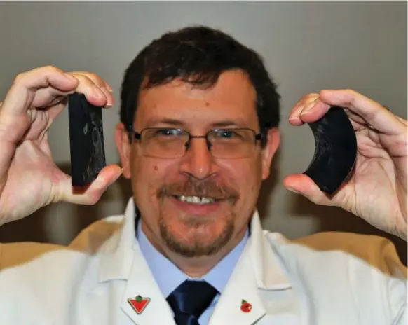  ?? JOHN MAHLER PHOTOS FOR THE TORONTO STAR ?? Joe Hallett, of ARTIS Research, holds two samples of tire rubber, chilled to -20 C. The all-season rubber on the left is no longer flexible, while the winter rubber on the right is still pliable.