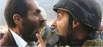  ?? (Mohamad Torokman/Reuters) ?? A PALESTINIA­N argues with an Israeli soldier during clashes over an order to close a Palestinia­n school near Nablus in West Bank