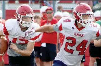  ?? PHOTO/CATHY SHORT ?? Cohen Watson (12) looks for room to run behind the block of Logan Taylor (24) during scrimmage at Plymouth.