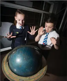  ??  ?? Above, Jessica McGrath, 10, and Callum Regan, 11, from St Mary’s Primary School in Maxwellton with a Victorian constellat­ion globe and below, collection­s assistant Stella Hook with a cast iron Victorian bike