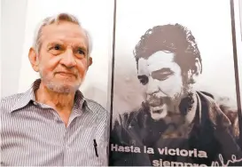  ??  ?? El autor junto a una de sus famosas fotos del Che Guevara.