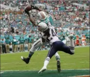  ?? LYNNE SLADKY - THE ASSOCIATED PRESS ?? Miami Dolphins wide receiver Brice Butler (14) catches a pass for a touchdown over New England Patriots cornerback Stephon Gilmore (24), during the second half of an NFL football game, Sunday, Dec. 9, 2018, in Miami Gardens, Fla.