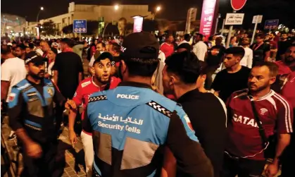  ?? ?? Supporters talk with police officers outside the stadium before the World Cup match between Morocco and Spain. Photograph: Hamad I Mohammed/Reuters