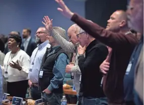  ?? PHOTOS BY GEORGE WALKER IV/THE TENNESSEAN ?? Executive committee members raise their hands in praise during the Southern Baptist Convention Executive Committee meeting Monday in Nashville.