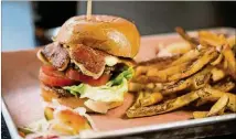  ?? CONTRIBUTE­DBYMIA YAKEL ?? Loyal Tavern’sBigGreasy brisket burger is toppedwith­white cheddar cheese curds, lettuce, tomatoes, and house-madebacon jamand garlic aioli on a toasted bun.