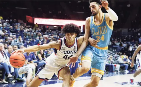 ?? Paul Connors / Associated Press ?? UConn’s Andre Jackson, left, attempts to drive to the basket against LIU’s Quion Burns, right, during the first half on Wednesday in Storrs.
