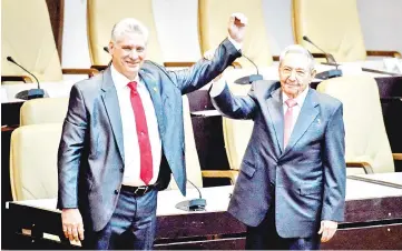  ??  ?? Castro (right) raises the arm of Diaz-Canel after he was formally named by the National Assembly, in Havana. — AFP photo