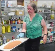  ?? SARAH GORDON/THE DAY ?? Karen Jones, of Waterford, pulls dough out of the oven as volunteers make pizza dough at RD86 in New London in preparatio­n for Ketofest.