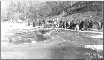  ?? Photo by Sam Wood; courtesy Rogers Historical Museum ?? C. Jimmie Carter retrieves his new Buick from the ice in Lake Atalanta in 1940. Hundreds of local citizens turned out to enjoy the