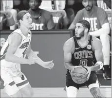  ?? MIKE EHRMANN/GETTY ?? Celtics’ Jayson Tatum drives the ball against the Heat’s Kelly Olynyk in Game 5 of the Eastern Conference finals on Friday in Lake Buena Vista, Florida.