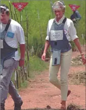  ?? PICTURE: ANTONIO COTRIM ?? Diana being accompanie­d through a minefield in Huambo, Angola in 1997.