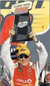  ?? Ross D. Franklin ?? The Associated Press Matt Kenseth holds up what may be his final winner’s trophy in Victory Lane on Sunday at Phoenix. The veteran racer does not have a ride for the 2018 season.