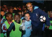  ??  ?? The Moura, the merrier: Spurs striker Moura is mobbed by kids on a visit to a Tottenham estate as part of the club’s Premier League Kicks programme