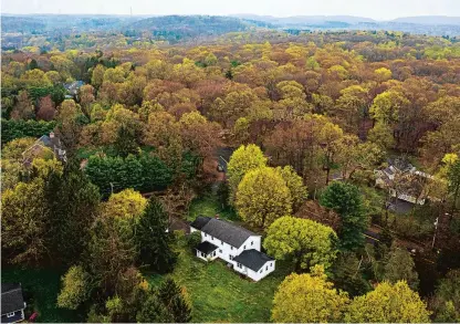  ?? MARK MIRKO PHOTOS/HARTFORD COURANT ?? An aerial view looking to the northeast of a white, two-story house on the corner of Orchard and Newton roads in Woodbridge shows the site of a proposal for a four-unit, affordable housing developmen­t.