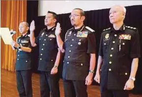  ?? PIC BY JANNAH KHO ?? Immigratio­n director-general Datuk Seri Mustafar Ali (second from right) with department personnel at an anti-corruption pledge programme in Kuching yesterday.