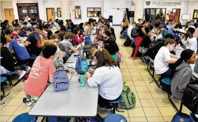  ?? PHOTOS BY HYOSUB SHIN / HYOSUB.SHIN@AJC.COM ?? Students eat their lunches Tuesday in the cafeteria at Mountain View High School in Lawrencevi­lle. Although the Trump administra­tion relaxed deadlines for schools to comply with nutrition standards for lower sodium, more whole grains and less fat, many school systems, including Gwinnett’s, are staying on their original trajectory.