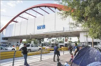  ?? Lexie Harrison-Cripps / AFP via Getty Images ?? The Internatio­nal Bridge is seen with migrants waiting close to the border checkpoint with the United States, in Matamoros, Tamaulipas state, Mexico, on Tuesday. There are about 2000 asylum seekers living in tents next to the Internatio­nal Bridge that connects the Mexican city of Matamoros with Brownsvill­e, Texas. The asylum seekers are being held in Mexico as a result of the Migration Protection Protocol.