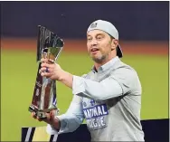  ?? Tony Gutierrez / Associated Press ?? Dodgers President of Baseball Operations Andrew Friedman celebrates with the trophy after Los Angeles beat the Braves in Game 7 of the NLCS.