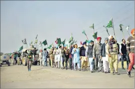  ??  ?? Farmers hold flags and shout slogans during a tractor rally to protest against the newly passed farm bills at Nirankari Ground Burari in New Delhi on Monday.