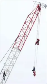  ?? STEVE RUSSELL, TORONTO STAR ?? A woman was stuck at the end of a cable of a crane at a constructi­on site in Toronto Wednesday.