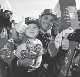  ?? JONATHAN FERREY/GETTY IMAGES ?? Kyle Larson celebrates with son Owen in Victory Lane after winning the Monster Energy NASCAR Cup Series FireKeeper­s Casino 400 at Michigan Internatio­nal Speedway on Sunday.