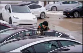  ?? (AP/The Dallas Morning News/Smiley N. Pool) ?? Cars line up last week at a vehicle battery charging station in Dallas. Tesla shares slid on Monday, wiping $15 billion from Elon Musk’s net worth.