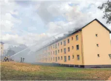  ?? FOTO: DPA ?? Die Feuerwehr löscht den Dachstuhlb­rand in einem Ankerzentr­um für Flüchtling­e.