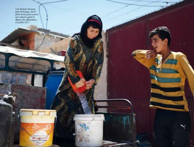  ?? © Afp/bulent Kilic ?? Une femme de Jazra, près de Raqqa, fait le plein d’eau pour sauver ses cultures après le départ des djihadiste­s, en juillet 2017.