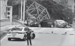  ?? CARLINE JEAN/SOUTH FLORIDA SUN SENTINEL ?? A constructi­on worker was killed and two people were taken to the hospital after a portion of a crane dropped onto the Southeast Third Avenue bridge over the New River in downtown Fort Lauderdale on Thursday.