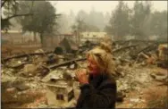  ?? AP PHOTO/JOHN LOCHER ?? Cathy Fallon reacts as she stands near the charred remains of her home in Paradise, Calif. “I’ll be darned if I’m gonna let those horses burn in the fire” said Fallon, who stayed on her property to protect her 14 horses, “It has to be true love.”