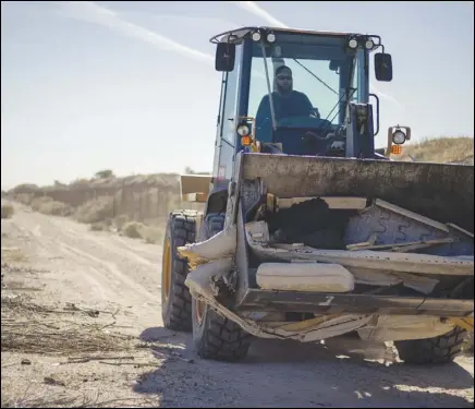  ?? RAYMOND GARCIA/ VALLEY PRESS ?? A tractor carries large items of debris dumped in an uninhabite­d area during a community cleanup Saturday morning near Avenue S and 70th Street East, near Pete Knight High School in Palmdale. The cleanup was the third event at the location for the Community Coalition of the Antelope Valley.