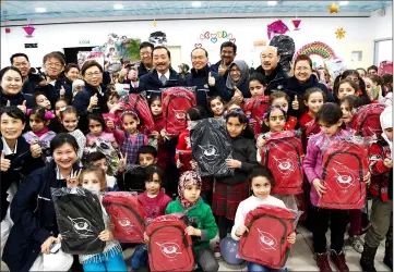  ??  ?? Vincent Tan, Lim Wee Chai and some volunteers take a group photograph after donating school bags to the Syrian children at El Menahil Internatio­nal School. — Bernama photos