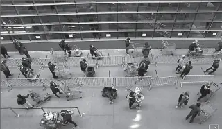  ?? NEW YORK
-AFP ?? Shoppers practice social distancing as they wait with their carts to enter a Target store in Manhattan during the outbreak of the coronaviru­s disease.